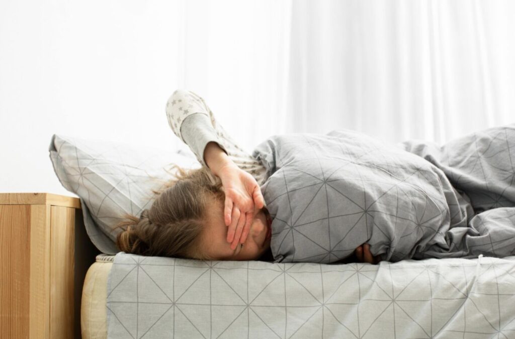 homme en train de s'étirer sur son lit