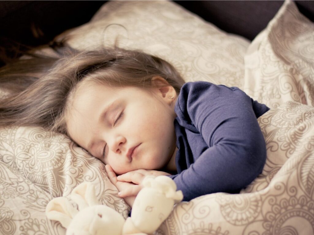 jeune enfant en train de dormir dans son lit