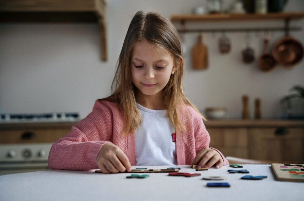 Jeune fille en train de faire un puzzle sur une table