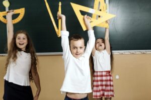 enfants dans une classe en train de bouger avec des équerres dans les mains