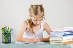Jeune fille en train d'écrire des phrases sur un cahier