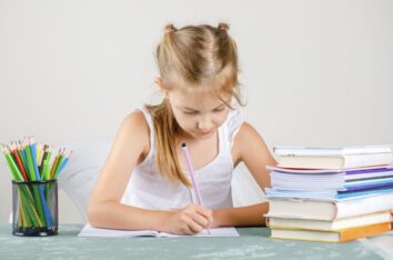 Jeune fille en train d'écrire des phrases sur un cahier