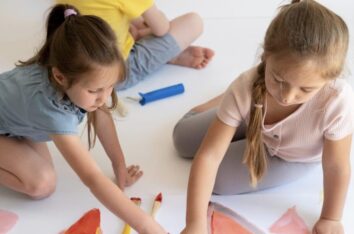 trois enfants en train de faire de la peinture en autonomie sans adulte avec eux