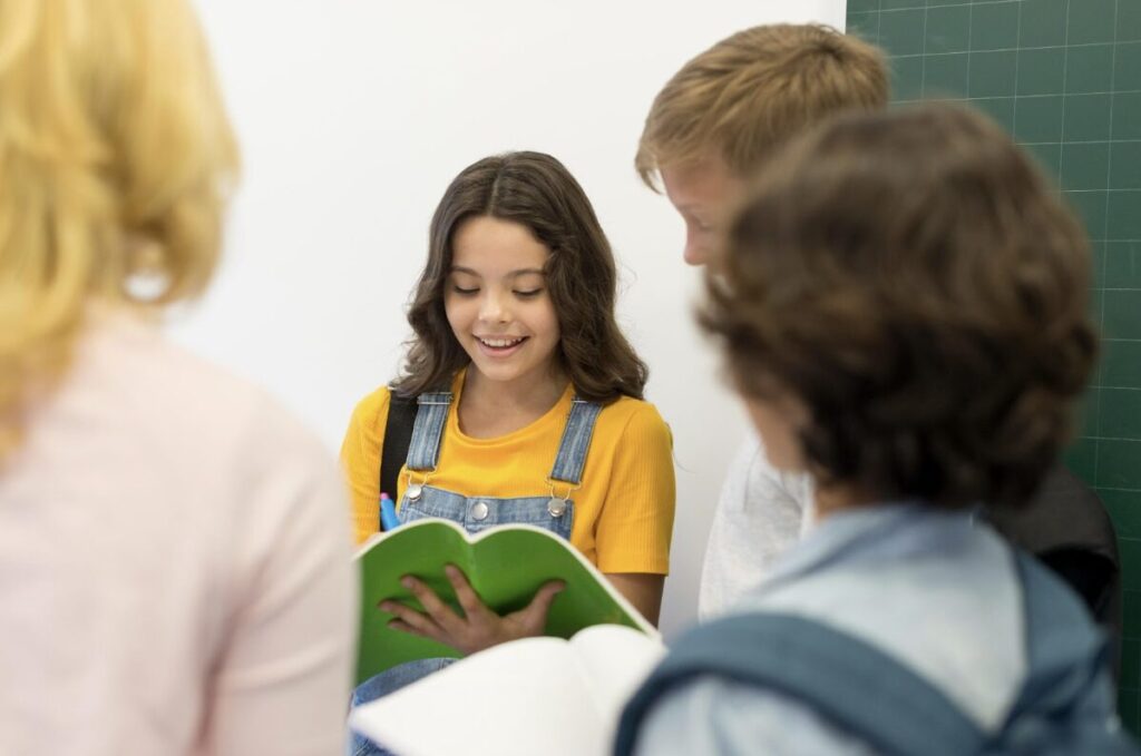 Groupe d'enfants qui regardent une jeune fille en train de lire un livre dans la joie