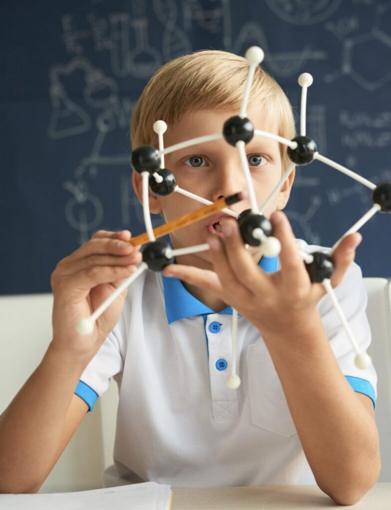 enfant en train de regarder un jeu géométrique et de réfléchir à la solution