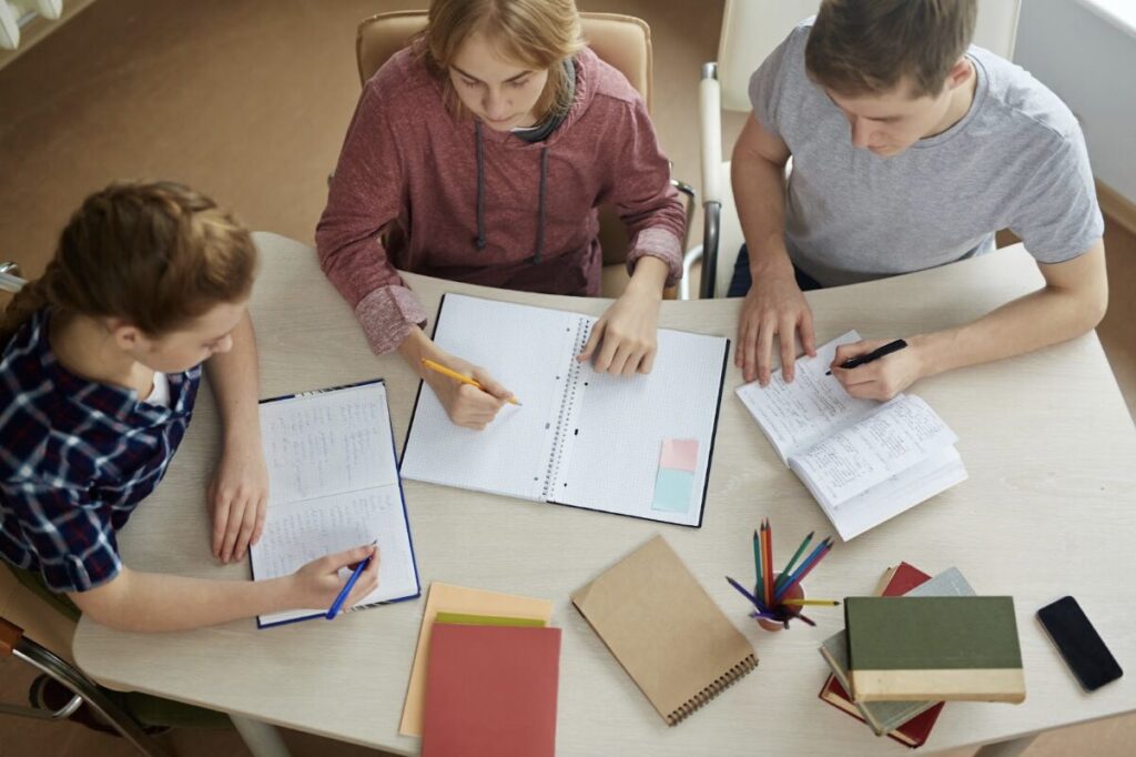 Etudiants en train de travailler ensemble avec des cahiers et des livres sur la table