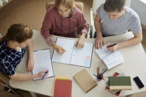 Etudiants en train de travailler ensemble avec des cahiers et des livres sur la table