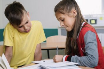 Deux élèves dans leur classe d'école en train de corriger les erreurs d'orthographe