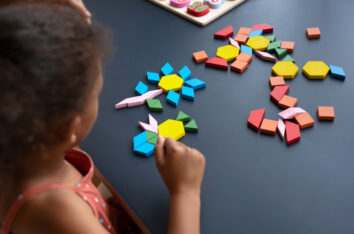 enfant qui fait une activité sensorielle sur les formes et les couleurs