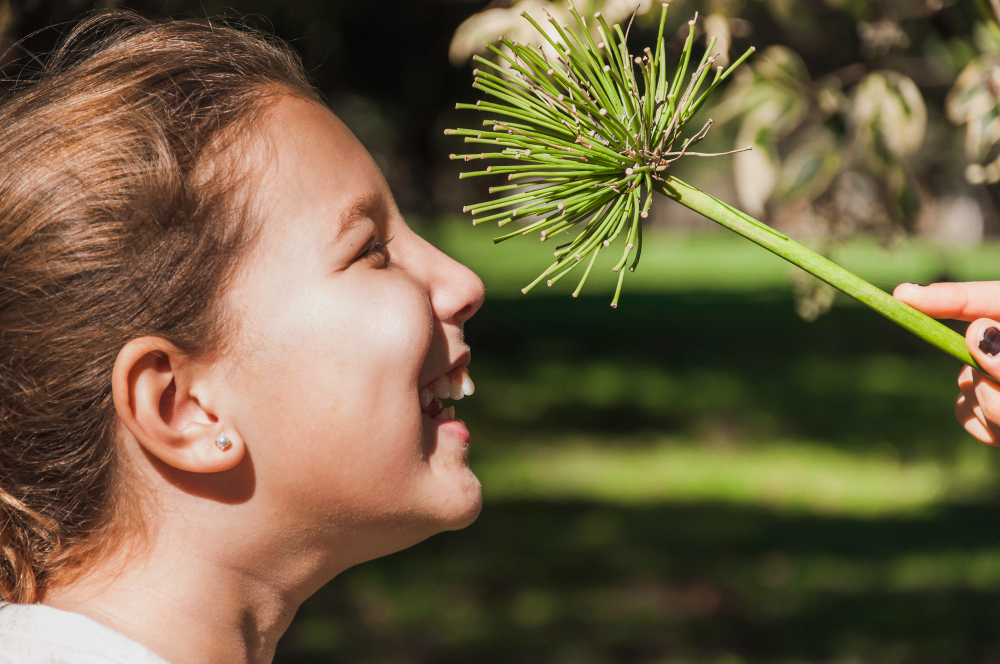 une jeune fille touche une plante avec son vsisage