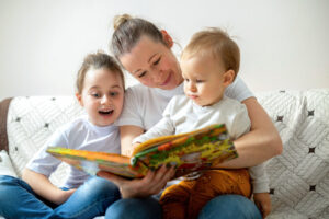 Une femme et deux enfants en train de lire une histoire
