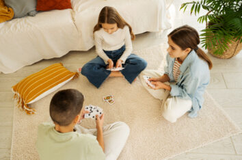 famille jouant à un jeu de société par terre
