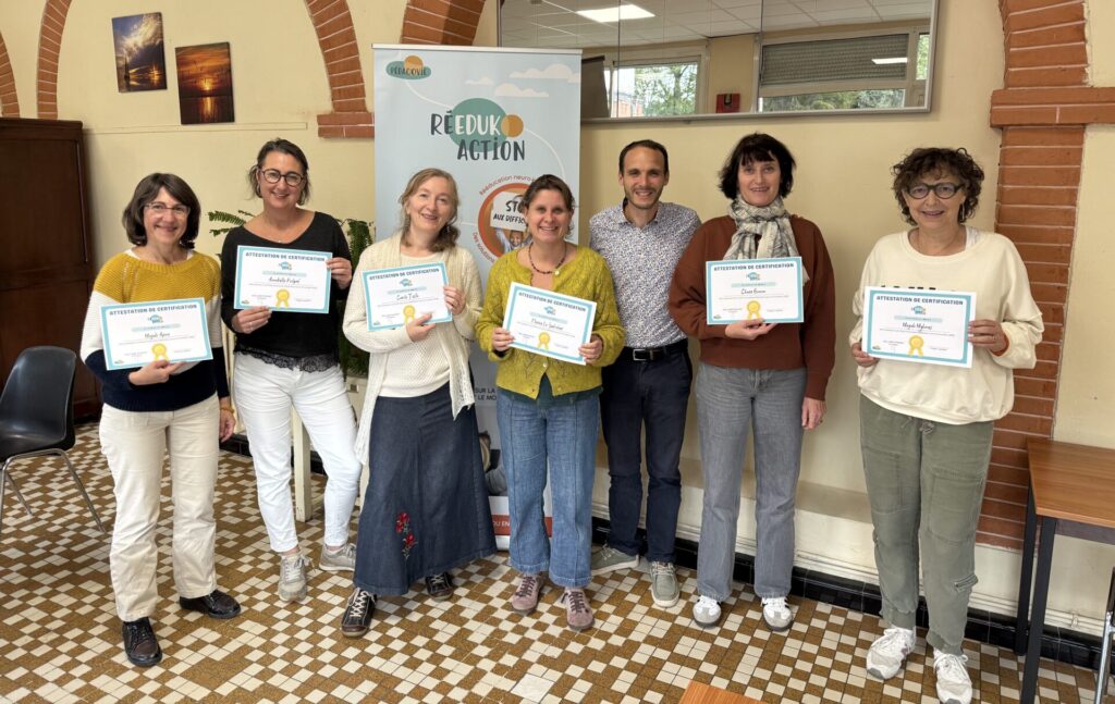 Groupe de personnes tenant une attestation de certification en main, formation reeduk'action obtenue après un parcours complet de formation