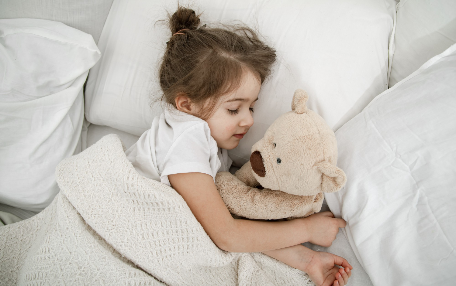 fillette qui dort dans son lit