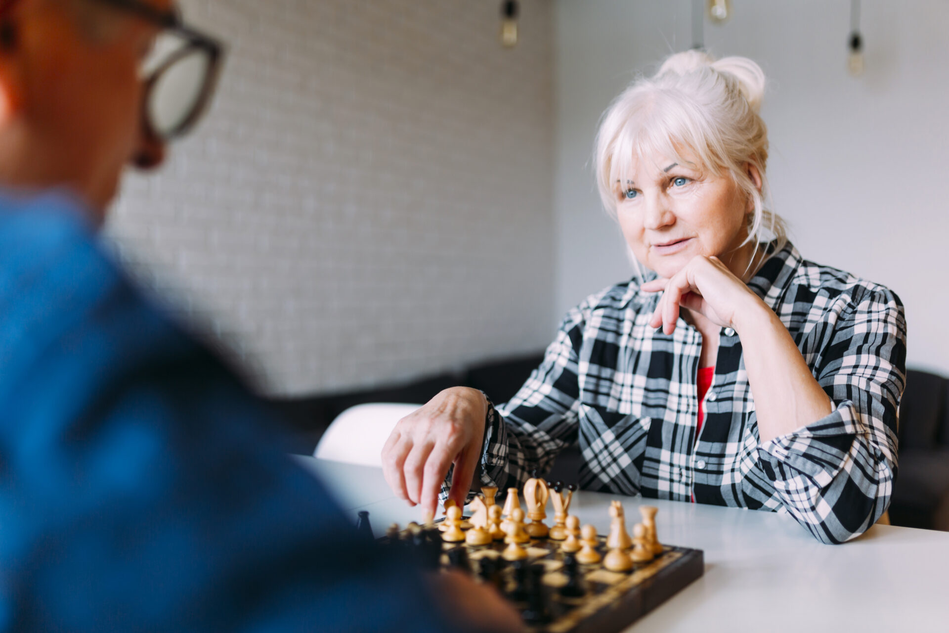 une personne senior joue aux échecs